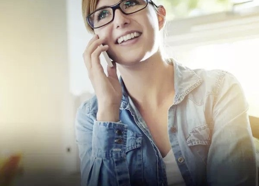 9zWq0-M5wKF A woman in glasses talking on the phone.