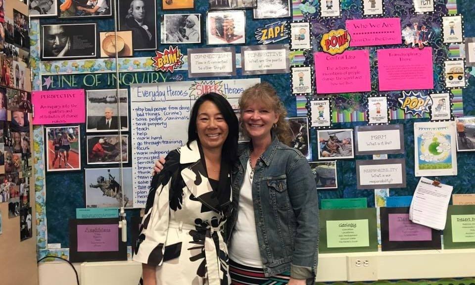 photo_upload_654d860f0e408-2023-11-10 Two women standing in front of a wall covered with pictures.